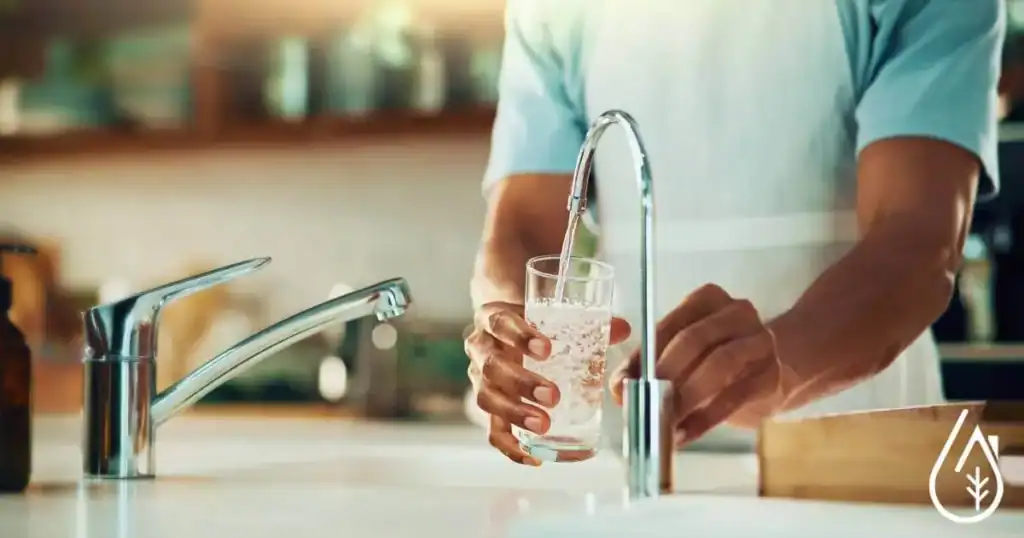 Lavabo de cuisine avec robinet en action pour laver un verre d'eau claire, concept de nettoyage et de désinfection de qualité, boutique Diproclean, produits professionnels pour l'entretien domestique et commercial.