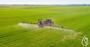 Fertilisation et traitement phytosanitaire dans un champ vert avec un tracteur pulvérisateur. Solution efficace pour la protection des cultures et l'agriculture durable.