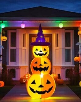 Pyramide de citrouilles lumineuses avec chapeaux de sorcière et décorations Halloween devant une maison, lumière chaude et festive.