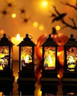 Quatre lanternes décoratives en métal noir avec silhouettes lumineuses et citrouilles d'Halloween, ambiance chaleureuse et festive.