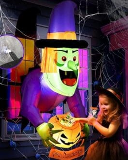Décoration festive Halloween avec un robot géant violet et une jeune fille déguisée, citrouille lumineuse et toiles d’araignée.